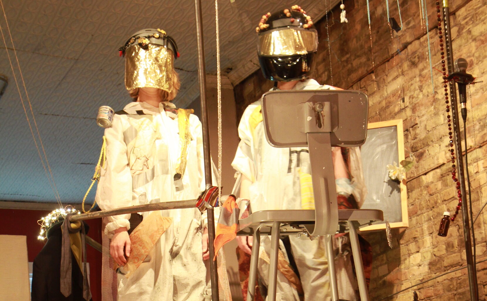 Two dancers in baggy suits with helmets on