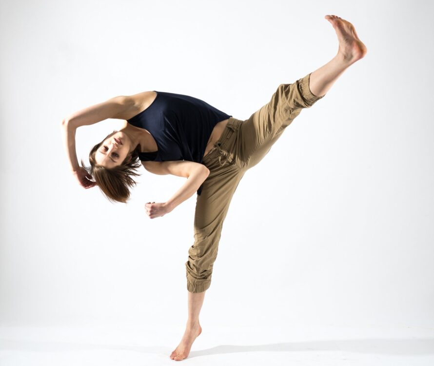 One dancer balanced on one leg and leaning away from an extended leg