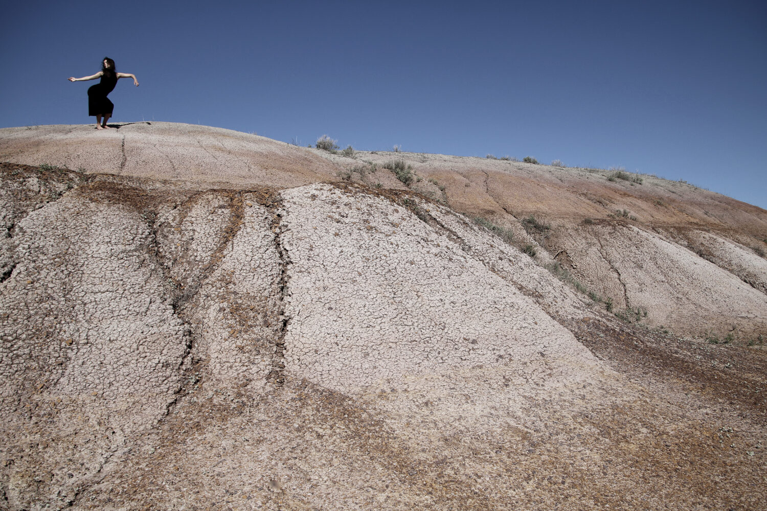 One person on a plateau, dancing against a dark blue sky