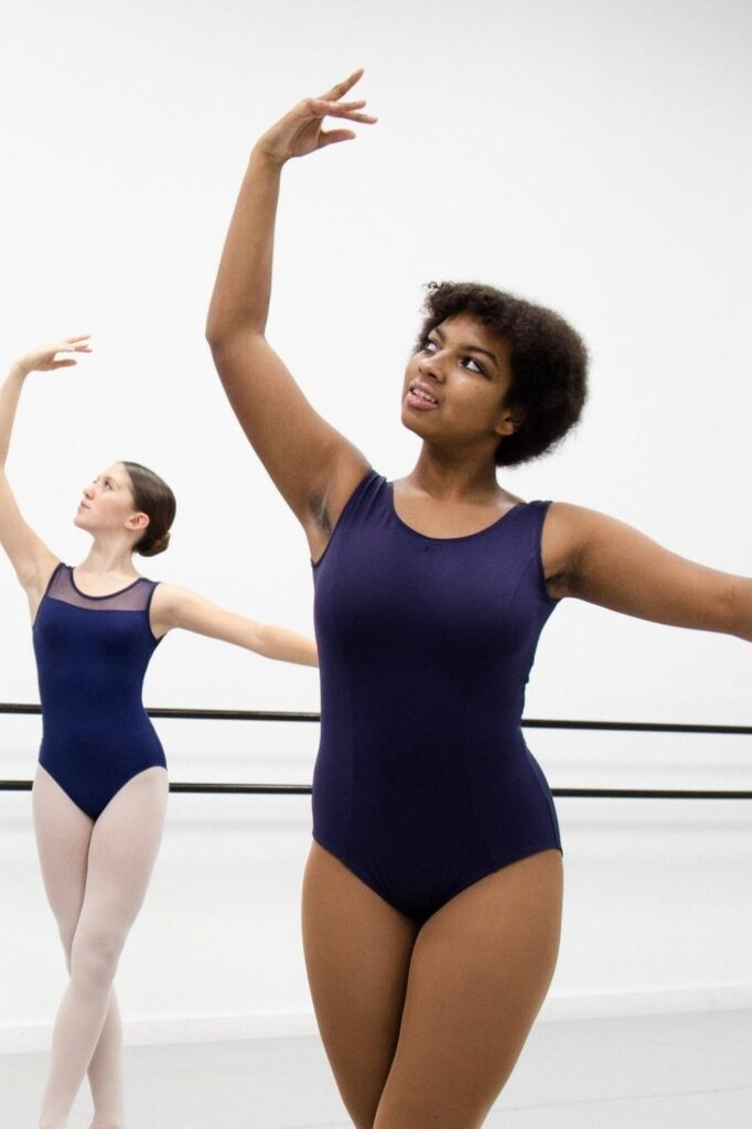 Dancers in navy blue leotards in ballet class